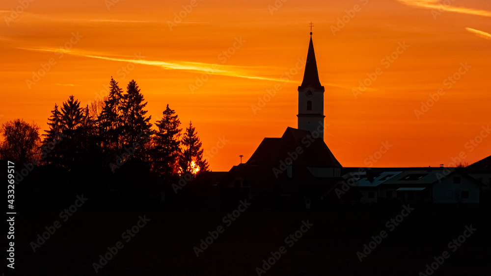 Beautiful sunset with a church silhouette near Kirchdorf, Bavaria, Germany