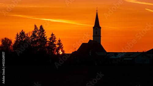 Beautiful sunset with a church silhouette near Kirchdorf, Bavaria, Germany © Martin Erdniss