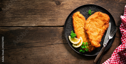 Canvas Print Homemade breaded wiener schnitzel served with parsley and lemon slices