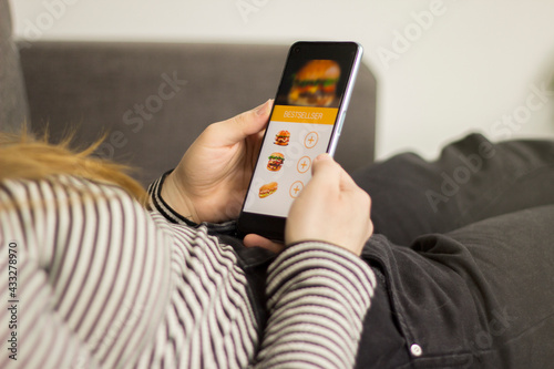 Ordering meal online burger mobile application young woman
