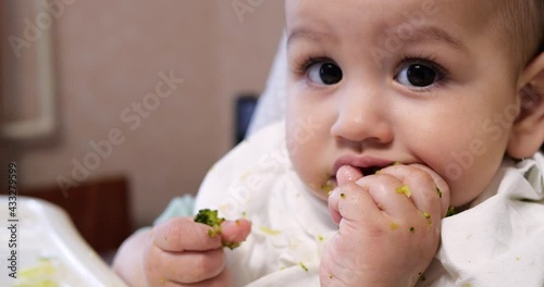 Mom feeds the boy with a spoon and hand, family food and parenthood concept. first complementary foods and self-feeding