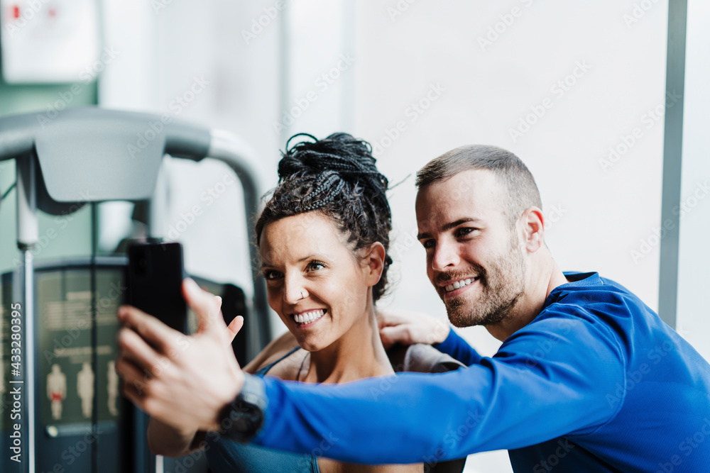 Smiling male and female sports people taking selfie in gym Smiling male and female sports people taking selfie in gym