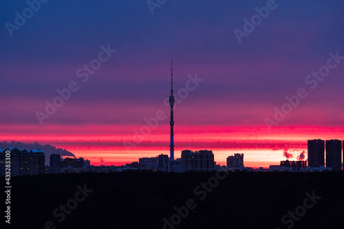 early sunrise over dark city park and TV tower