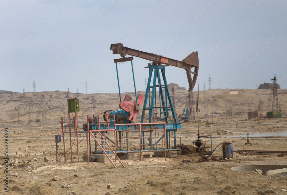 Oil and gas drilling rig onshore dessert with dramatic cloudscape . Land oil drilling rig blue sky .Land rig during the drilling operation Oil and gas drilling rig onshore dessert with dramatic cloudscape . Land oil drilling rig blue sky .Land rig during the drilling operation