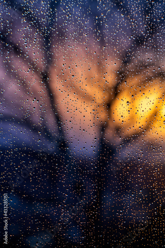 Raindrops on window pane at sunset photo