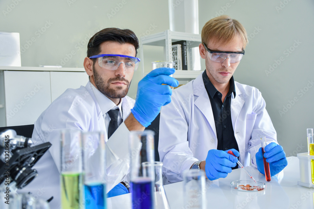 Two scientists talk about chemical samples in the lab about the results of the experiment. Two scientists talk about chemical samples in the lab about the results of the experiment.