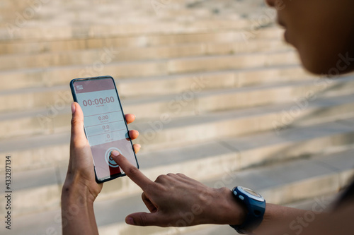 Sportswoman setting timer on smart phone