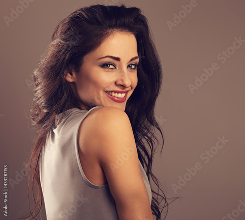 Beautiful happy toothy laughing woman with bright makeup on grey background with empty copy space. Closeup beauty