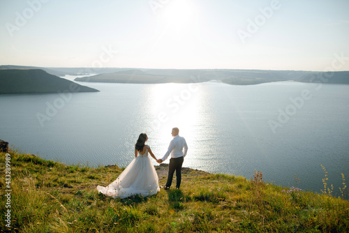 Sensual wedding couple groom and bride near the beautiful lake