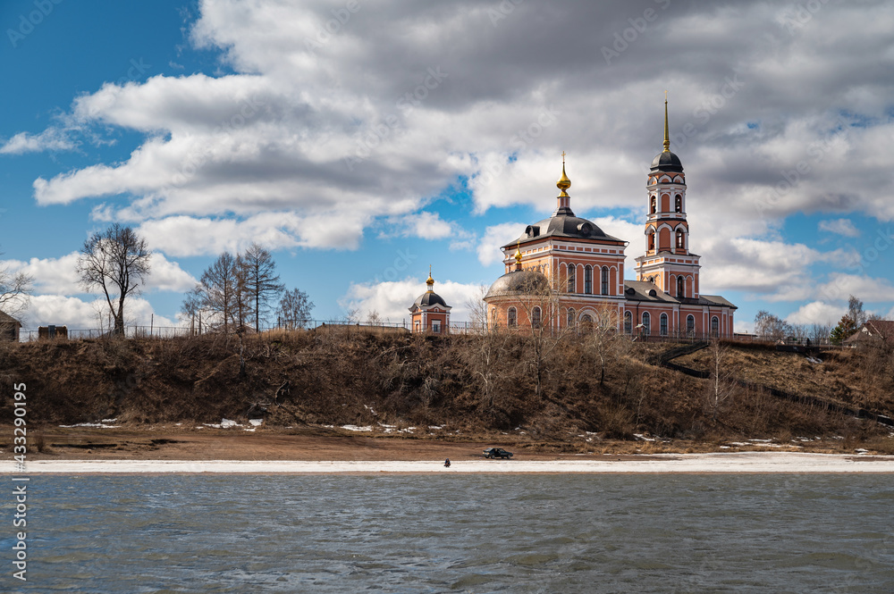 Holy Trinity Church in the village of Nizhni Mully, Perm, Russia, view from the Kama River on a sunny day in early spring.