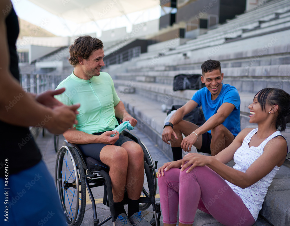 Happy athletes laughing and talking in bleachers Happy athletes laughing and talking in bleachers