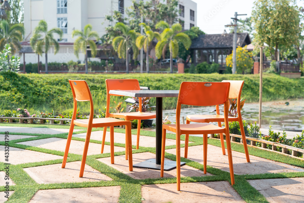Three plastic chairs with table in the garden.
