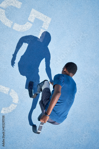 Male amputee sprinter on blue sports track photo