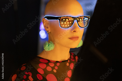 Portrait stylish woman in neon glasses and earrings photo