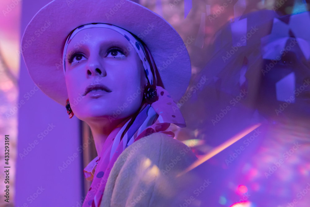 Portrait beautiful fashionable woman in fedora under neon lighting