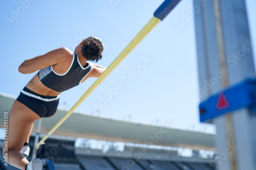 Female track and field athlete high jumping photo