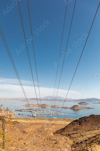 High voltage wires carry power from Hoover Dam over the hills above a marina in Lake Mead
 photo