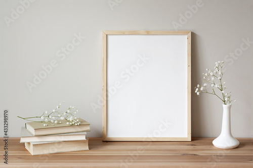 11x14 thin wood vertical frame mockup for art and quotes. Vintage stack of books and flowers as props.