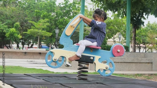 A Little kid are playing with rocking horse at the playground, kids having fun and excited, activities kids. Looking at the camera, enjoy and leaning outdoor of kids concept, slow motion concept.
