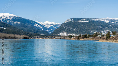 early spring Columbia river panorama with snow on mountains blue sky British Columbia Canada