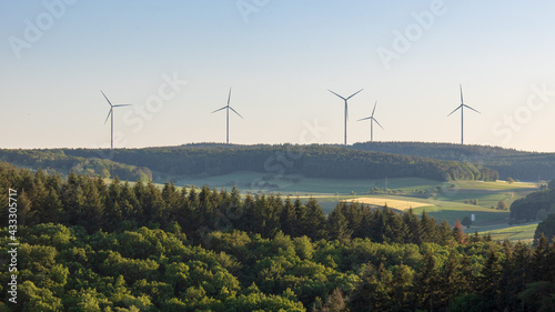 Wind turbines at the horizon in green rural landscape in Werbach, Germany.  Alternative renewable green energy 
