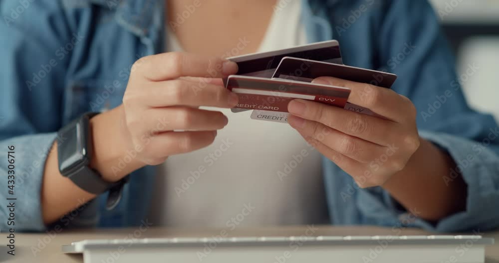 Young asia lady using computer order online shopping product and paying bill with credit card in living room interior. Stay at house, Self quarantine activity, Fun activity for coronavirus prevention.