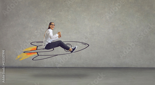 Side view of excited smiling laughing woman flying in air riding hand drawn cartoon doodle rocket with burning blast off flame. Using creative power, reaching success, achieving business goal concept photo
