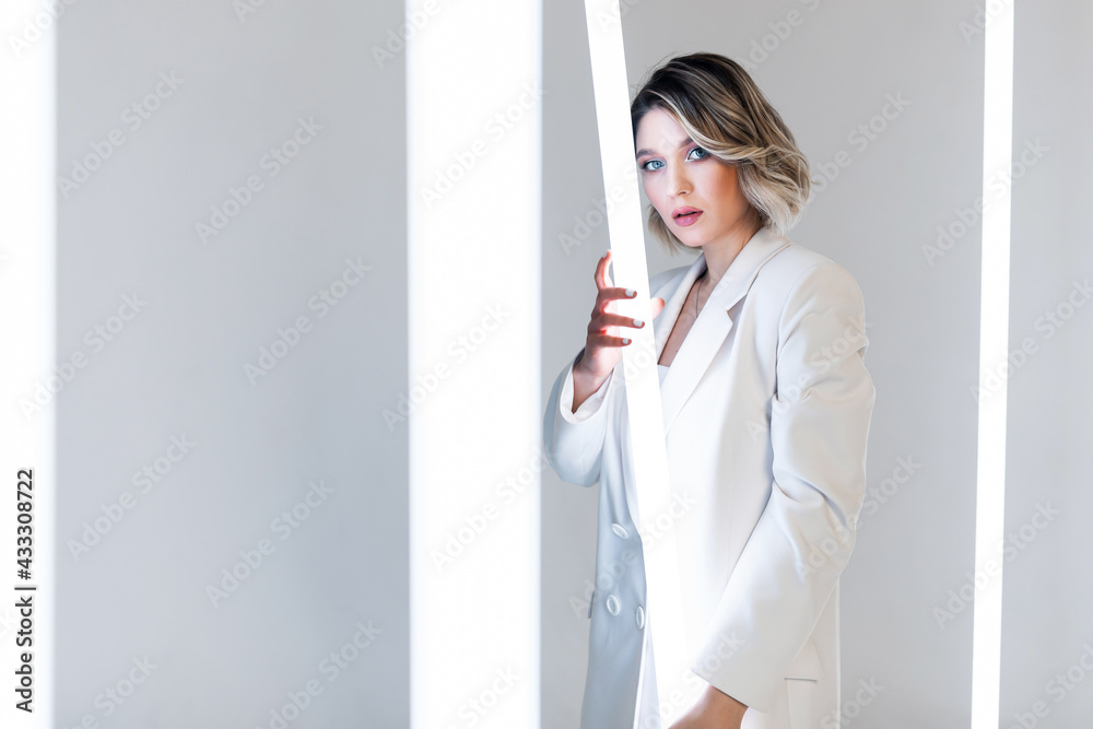 singer posing in the studio. Around the girl neon lamps singer posing in the studio. Around the girl neon lamps