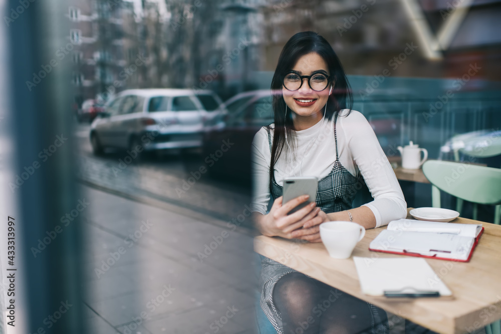 Happy lady using smartphone in cafe in day off