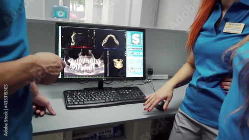 Dentists are discussing dental problems at report x-ray image on laptop screen t