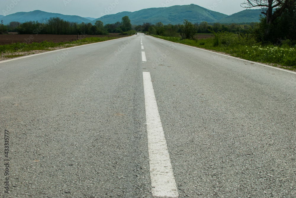 Asphalt surface of country road closeup on countryside landscape background Asphalt surface of country road closeup on countryside landscape background