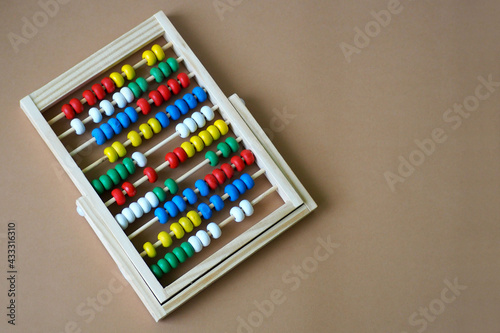 wooden baby abacus lie on brown background top view