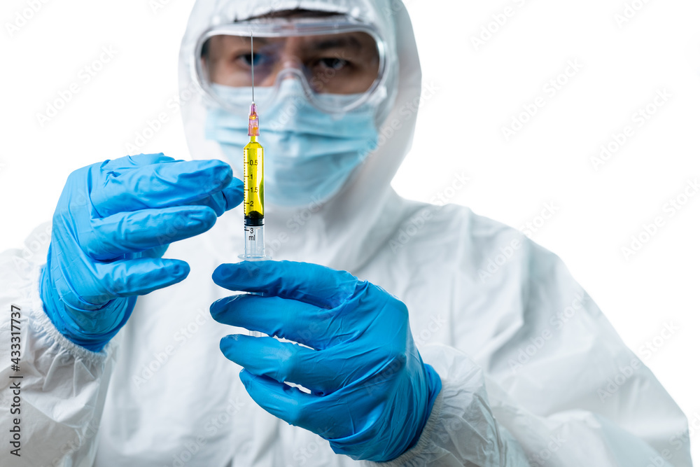 Doctor hand in protective suit holding syringe with white background Doctor hand in protective suit holding syringe with white background