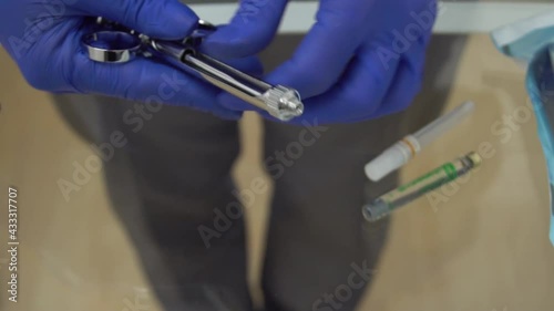 Slow Motion Medic hands in blue protective gloves with anaesthesia syringe. Dent