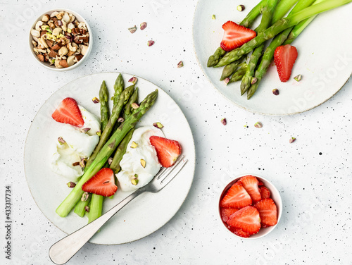 asparagus with cheese, nuts and strawberry on a plate