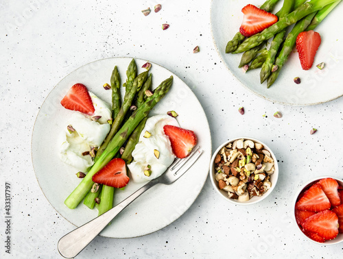asparagus with cheese, nuts and strawberry on a plate