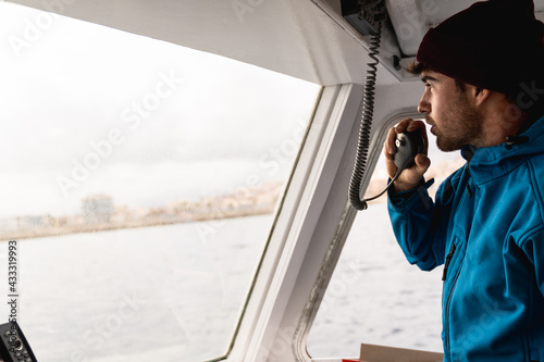 Young skipper man sailing a boat working during summer vacation - Focus on face