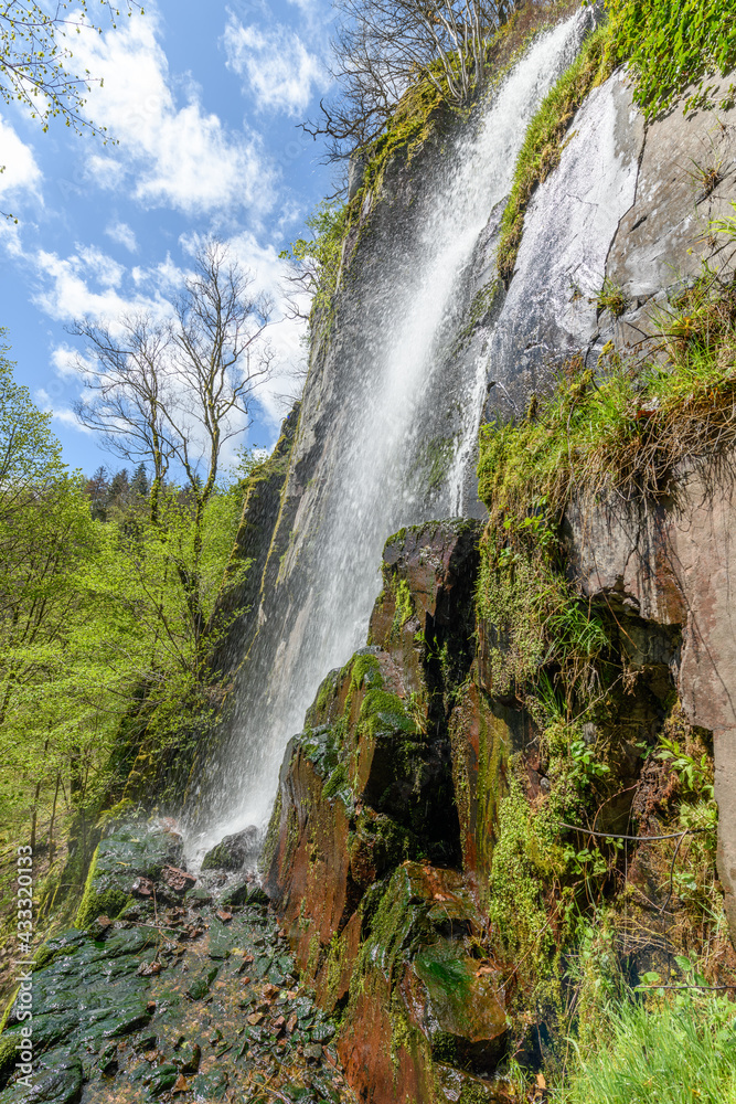 Obraz premium Waterfall in a mountain forest in early spring.