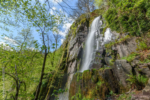 Waterfall in a mountain forest in early spring.