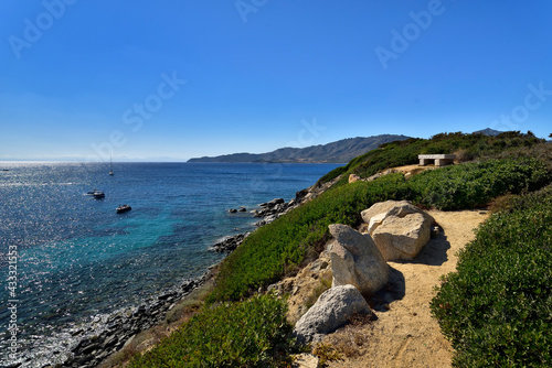 Stone bench with amazing view of pure clear azure coast near the Spiaggia di Mari Pintau beach in Sardinia, Sardinia, Italy.