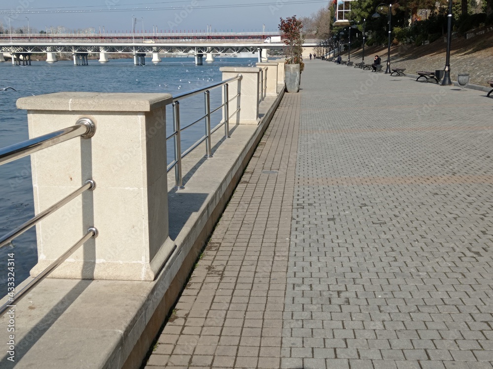 The park's terrace on the back is the Kura River . The blue river, the bridge and a view of the Kura River, Migechevir, Azerbaijan. ron terrace overlooking the river.