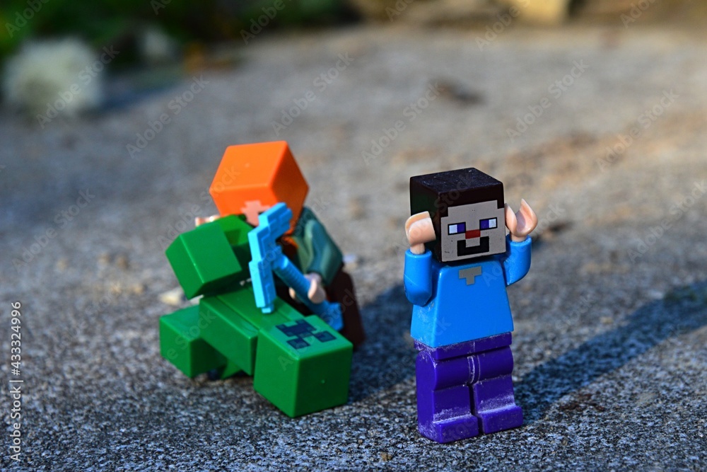 LEGO Minecraft Steve figure running from Alex with diamond pickaxe fighting  with explosive green Creeper mob monster on large stone block. Stock Photo  | Adobe Stock