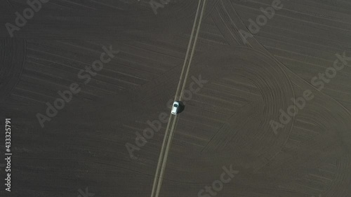 empty field top view, on a narrow road, a trail is symmetrically white car, graphic, geometric space, landscape abstraction