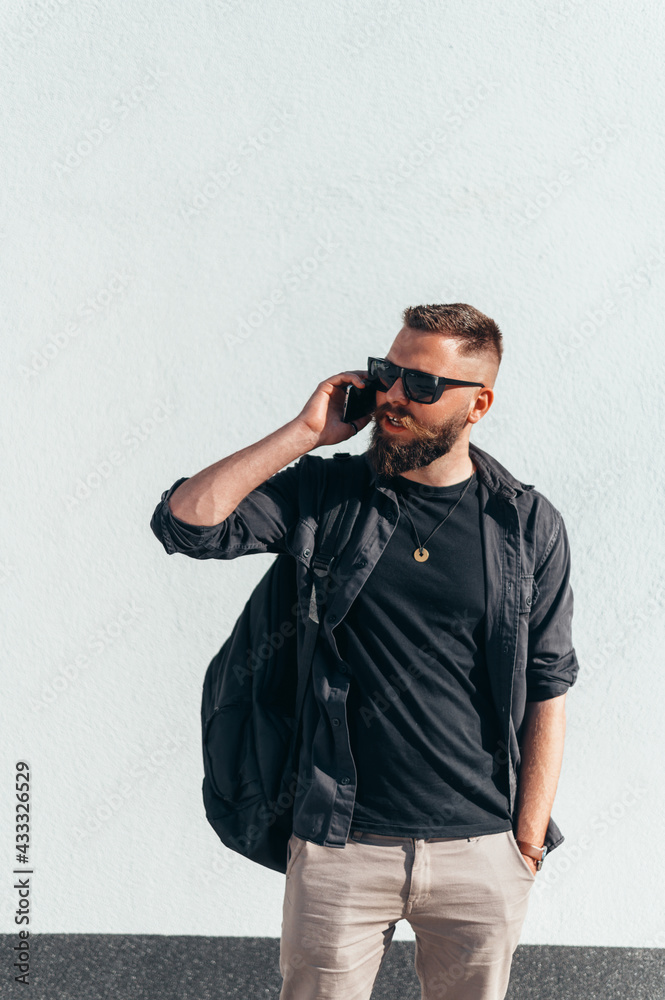 Young handsome man using a smartphone outside with a white background Young handsome man using a smartphone outside with a white background