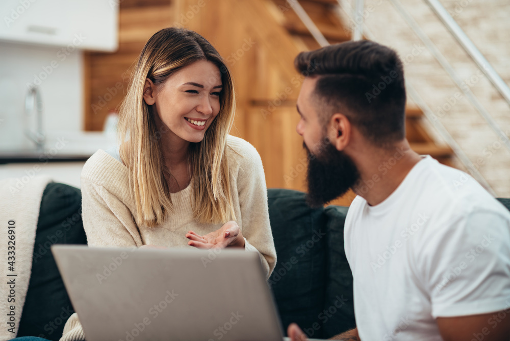 Young beautiful couple using a laptop at home Young beautiful couple using a laptop at home