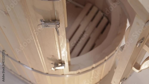 Cedar phytobarrel with wooden door,handle inside with grate for sitting closeup