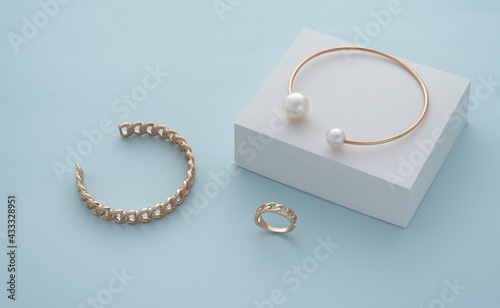 Golden pearl bracelet on white box and golden chain shape bracelet and ring