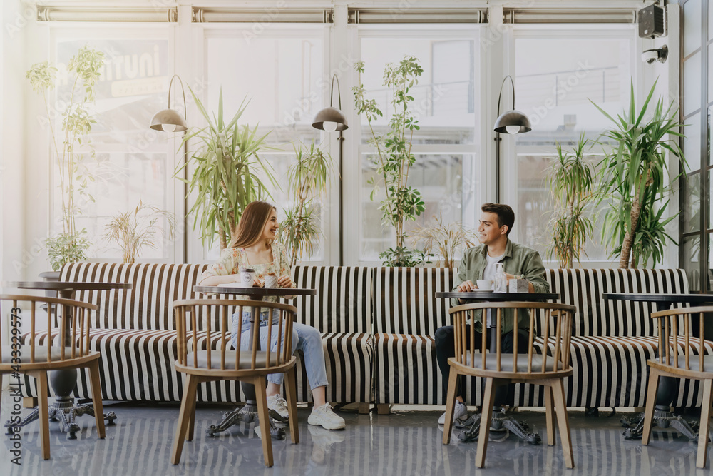 Fototapeta premium Young couple using disinfectant at coffee shop