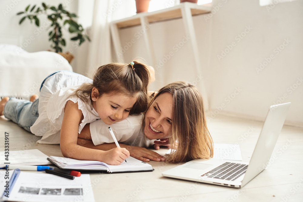 mom works at the computer while playing with her daughter mom works at the computer while playing with her daughter