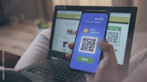 Close up of an African-American male hand holding smartphone, using a mobile crypto wallet with QR scan for online shopping photo